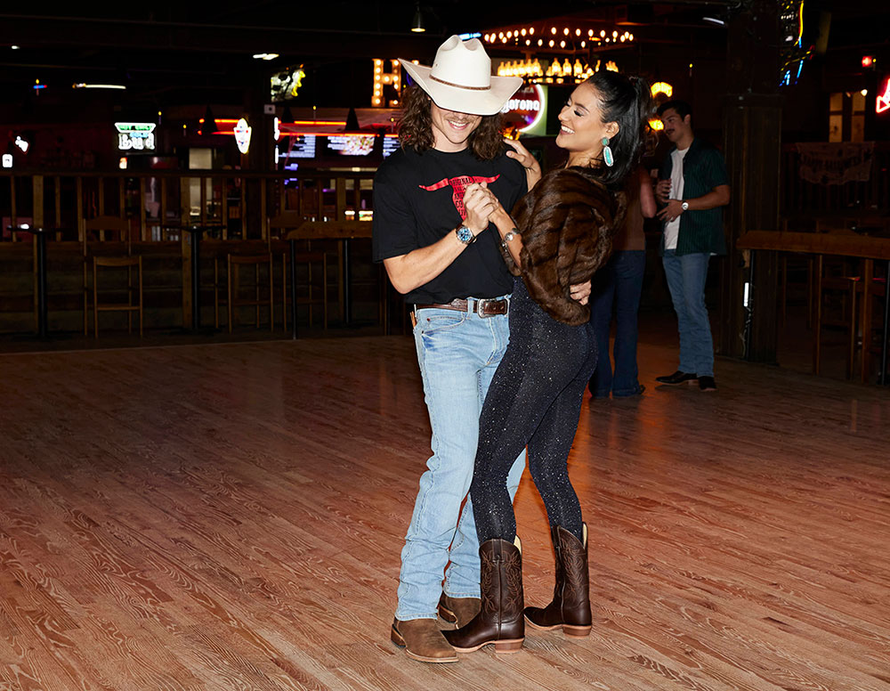 A man and a woman wearing Justin western boots while dancing.